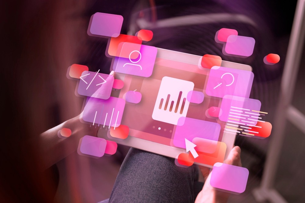A person holds a tablet displaying a data analytics app with floating digital icons around it. Showcasing tailored UI-UX designs, the icons include graphs, user profiles, and coding symbols in shades of pink and purple.