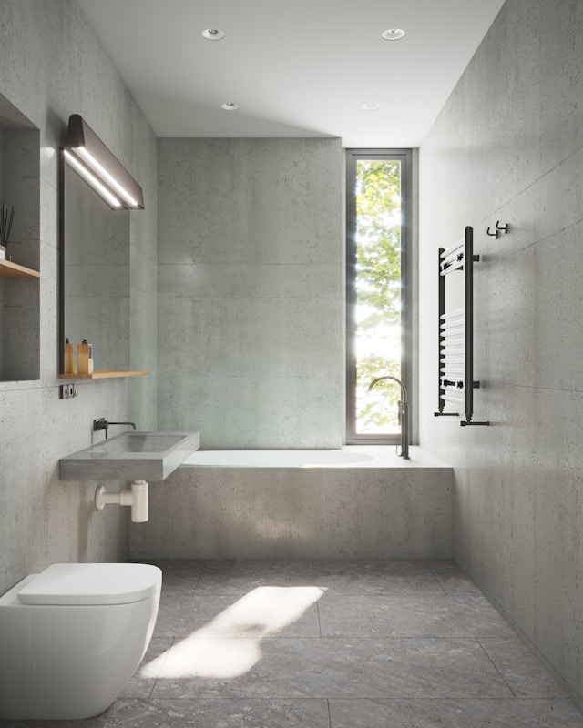 A modern bathroom featuring a minimalistic design with gray concrete walls and floors. 