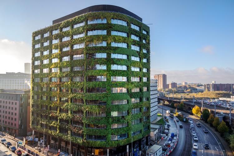Exterior view of the Eden Building in Salford featuring a large living wall and sustainable facade design