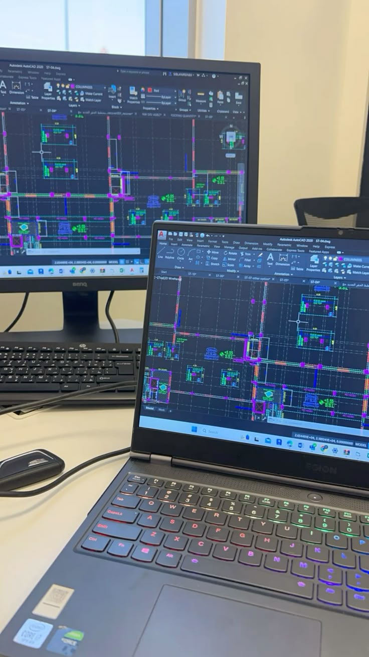 Architect working on Revit 3D model on dual screen.