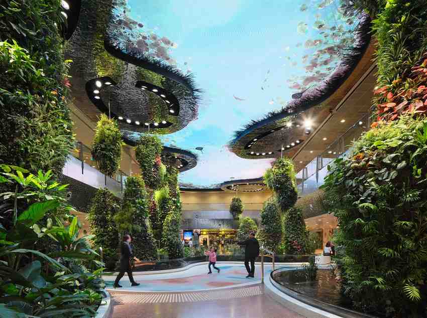 A modern atrium featuring vertical gardens and ceiling art depicting the sky and birds showcases innovative green building techniques. 