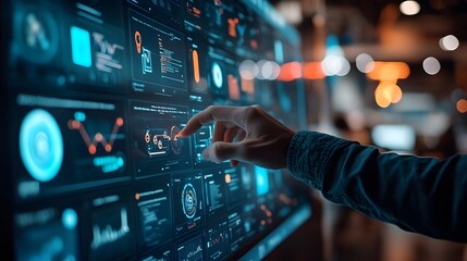 A person's hand interacts with a large digital screen filled with colorful charts, data visualizations, and icons. This scene, set in a dimly lit, modern tech environment, showcases interactive models that bring the UI/UX design to life.