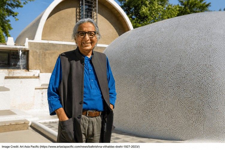 Balkrishna Vithaldas Doshi standing outdoors beside curved concrete architecture at his Ahmedabad studio complex.