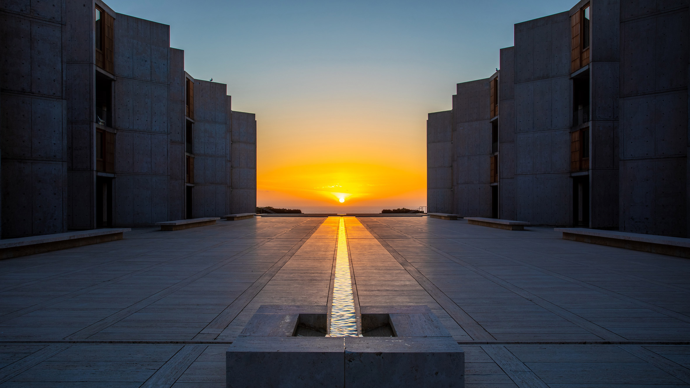 Salk Institute’s open corridor framing a distant view of the ocean and sky, blending architecture with nature