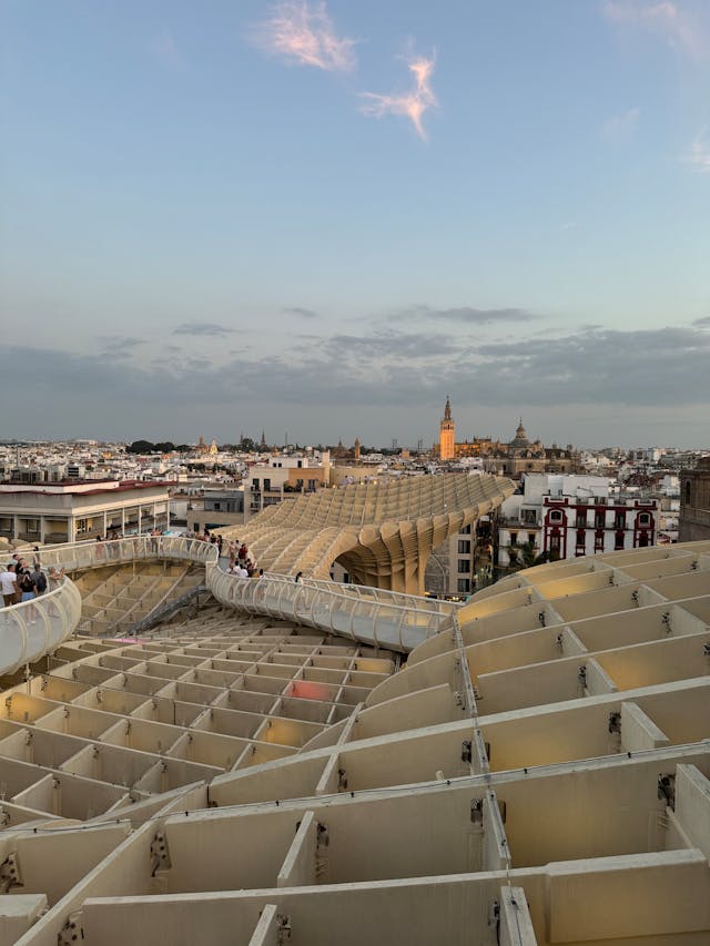 View of the Metropol Parasol in Seville at sunset, its wooden lattice showcasing the ingenuity of architects skilled in parametric design. 