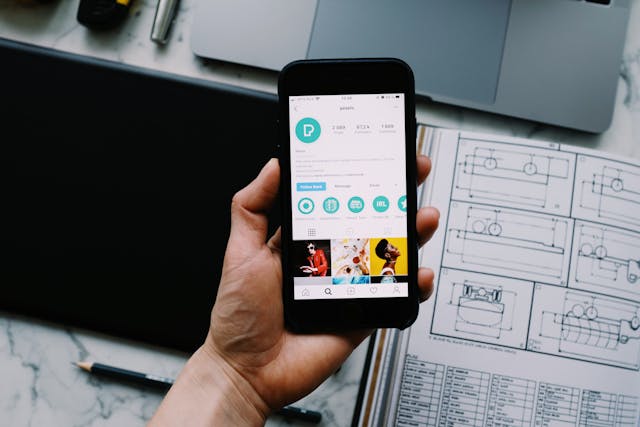 A person holds a smartphone displaying a social media profile, illustrating the essence of UX design. The screen showcases various icons and images.