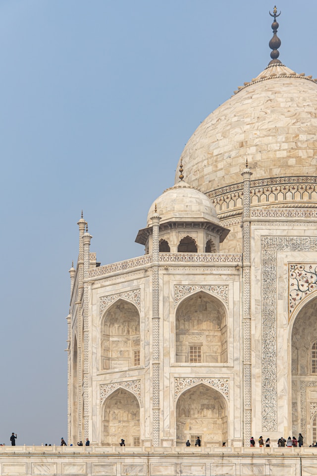 A close-up of the Taj Mahals marble facade and domes on a clear day highlights its status as a global heritage site. 