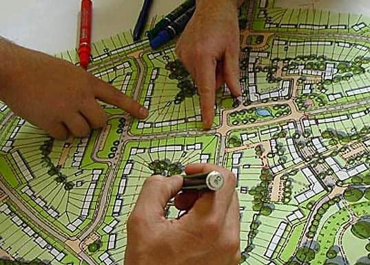 Urban planner analysing city zoning and infrastructure maps on GIS.*