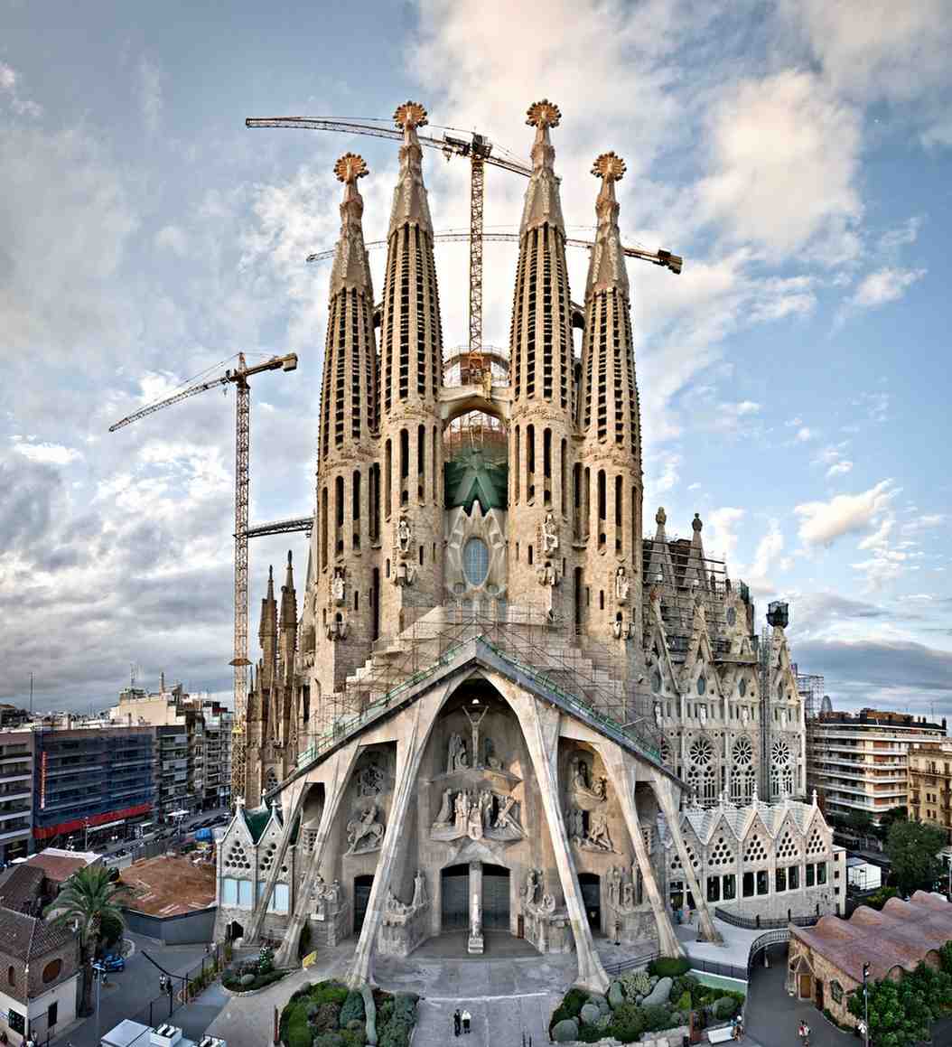Exterior view of the Sagrada Familia, showcasing its towering design and surfaces engineered to enhance sound reflection and resonance, aligning with its spiritual and acoustic principles.
