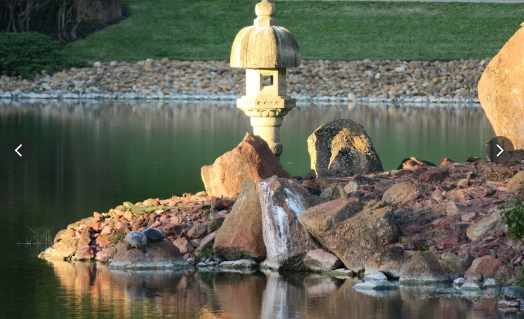 statue highlighting the golden light falling on brink of shore of the lake