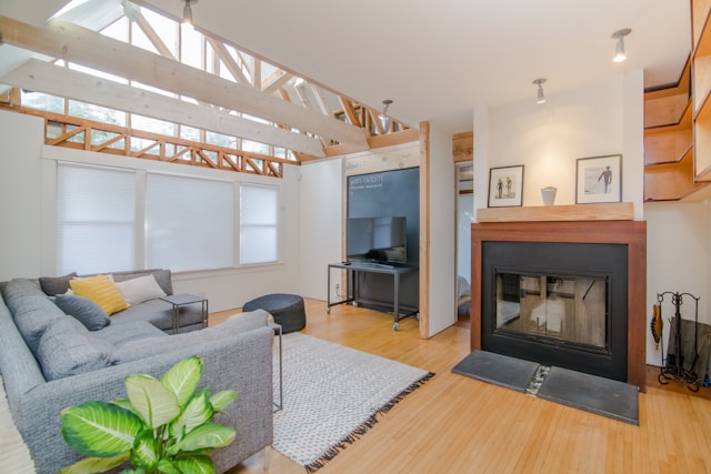 A modern living room with a gray sectional sofa, a fireplace, and a flat-screen TV adheres to Vastu design principles. 