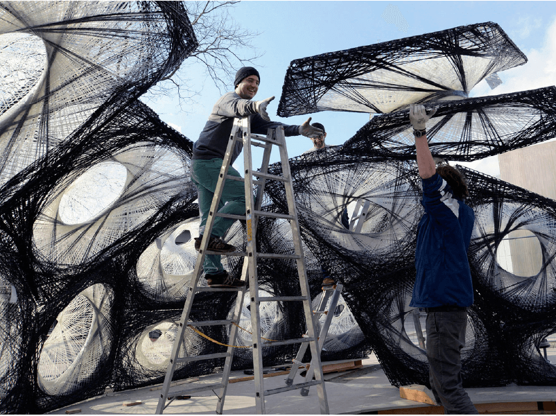 Professionals installing a parametrically designed installation