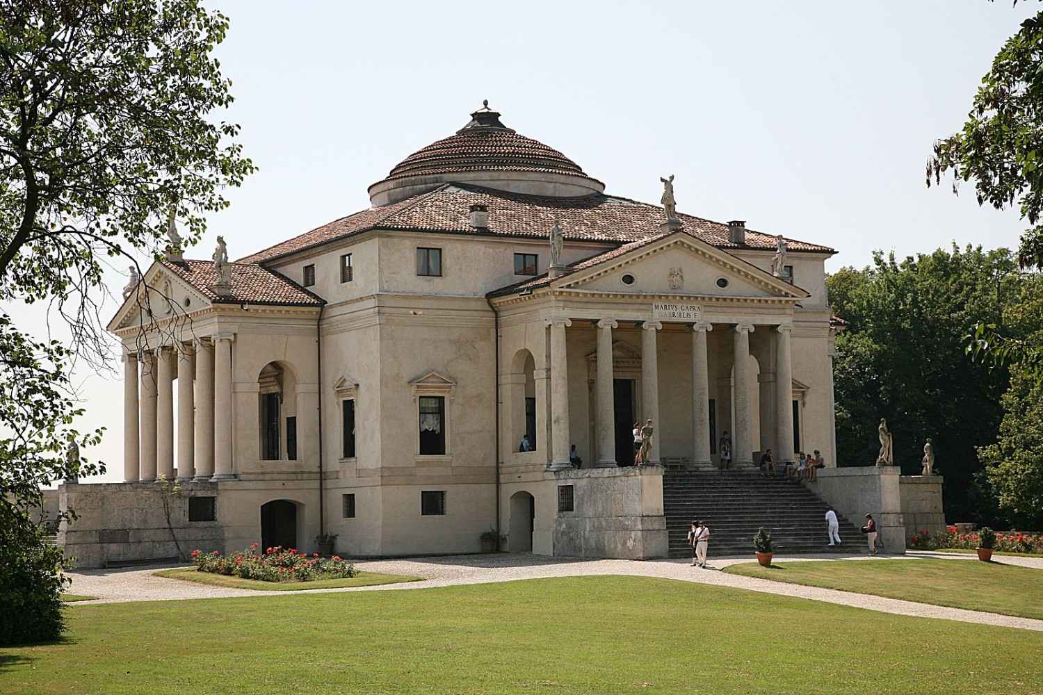 A grand neoclassical villa with a symmetrical design, crafted by visionary architects, features a central dome and four porticos with columns.
